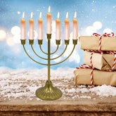 Jewish Candle Holder metal 7-branch menorah with lit candles and holiday gift boxes on wooden surface
